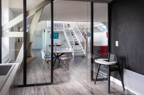 une chambre avec une table, des chaises et un escalier dans l'établissement Le Loft des Artistes - Repas & Vins possibles sur demande, à Sainte-Savine