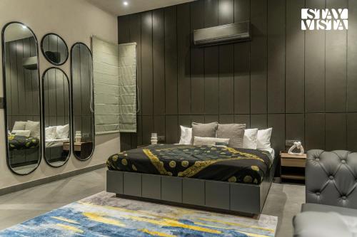 a bedroom with a bed and a wall with mirrors at StayVista at Urban Escape - 2 Pools, Lawn & WiFi in Jaipur