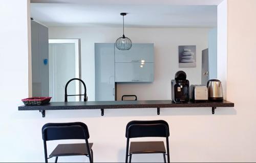 une cuisine avec un comptoir et 4 chaises. dans l'établissement Spacieux T3 Sète, parking, 10 min à pied gare et centre ville, wifi, clim, à Sète