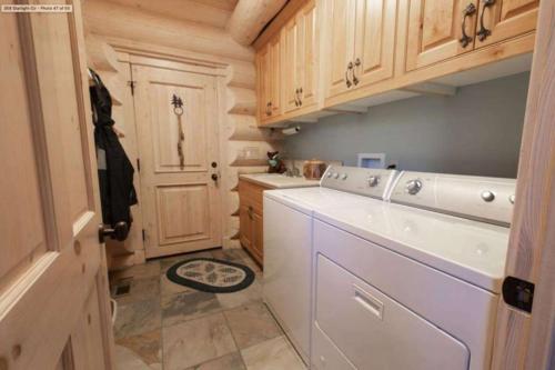 a small kitchen with a white washer and dryer at Hot Tub Game Room Large Deck w Incredible View Penticton Lodge by AvantStay in Big Bear Lake