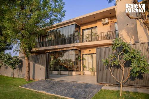 an exterior view of a house with a balcony at StayVista at Urban Escape - 2 Pools, Lawn & WiFi in Jaipur