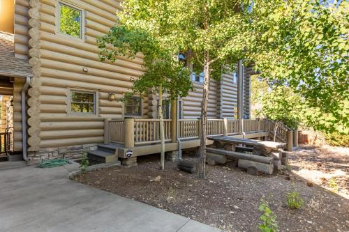 a wooden cabin with a porch and a tree at Hot Tub Game Room Large Deck w Incredible View Penticton Lodge by AvantStay in Big Bear Lake