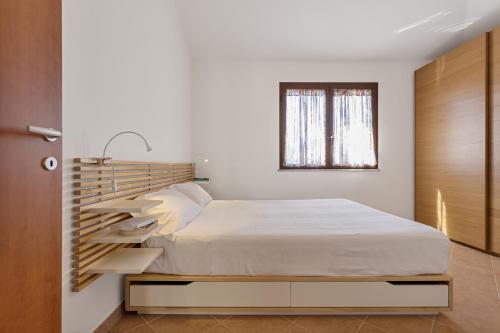 a bedroom with a bed with a wooden headboard at Casa Luna in Tertenìa