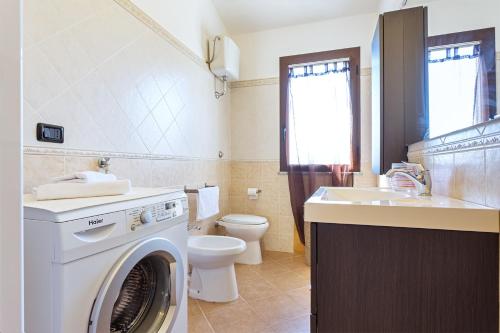 a bathroom with a washing machine and a sink at Casa Luna in Tertenìa