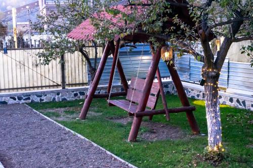 a swing set in a yard next to a tree at Bob’house in Vulcan
