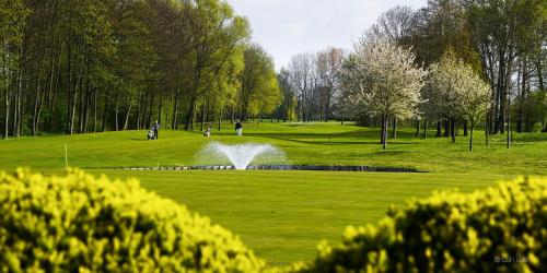 a pond in the middle of a park with a fountain at "ZeeLandZon" Holiday home by the lake with Jacuzzi and Sauna in Herkingen