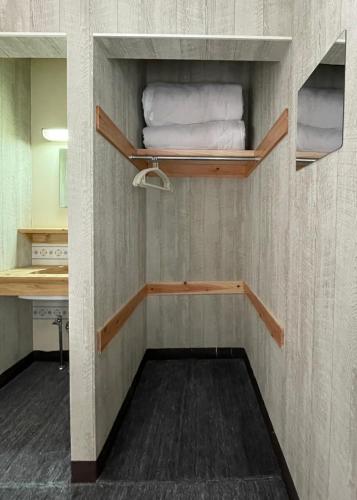 a bathroom with shelves and towels in a room at Restmance Pension Woody Hill in Iiyama