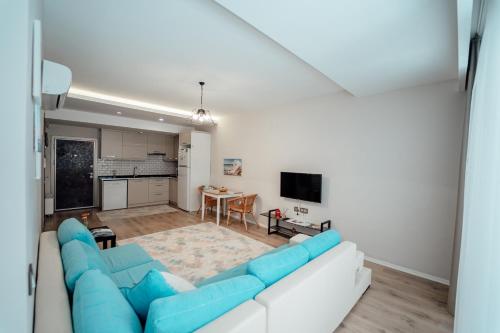 a living room with a blue couch and a kitchen at Fortunella Suites in Finike