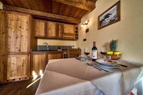 a kitchen with a table with a bottle of wine at MCX Vacation Rental - MAISON LOZ Duplex in villaggio tipico Valdostano con comfort moderni e panorama mozzafiato in Valtournenche