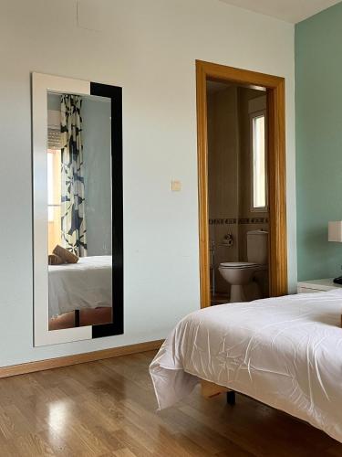 a bedroom with a mirror and a bed and a bathroom at El Chalete in Otura