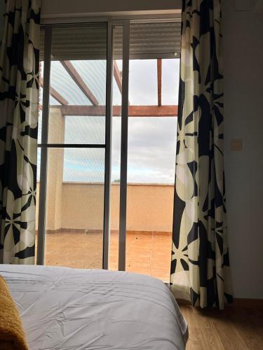 a bedroom with a bed and a large window at El Chalete in Otura