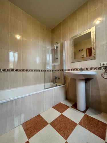 a bathroom with a sink and a tub and a mirror at El Chalete in Otura