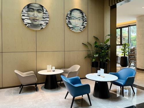 a restaurant with two tables and chairs and portraits on the wall at Holiday Inn - Nanjing South Station by IHG in Nanjing
