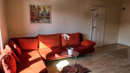 a living room with a red couch and a table at Villa Gartenblick in Kufstein