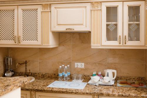 a kitchen with white cabinets and a counter top at Chevalier Hotel & SPA in Bukovel