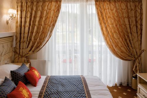 a bedroom with a bed and a large window at Chevalier Hotel & SPA in Bukovel