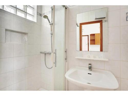 ein weißes Badezimmer mit Waschbecken und Dusche in der Unterkunft City Cottage le Montreuillois in Montreuil