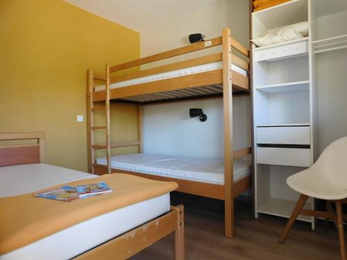a bunk bed room with two bunk beds and a desk at Village de Gîtes Nature et Jardin in Bouère