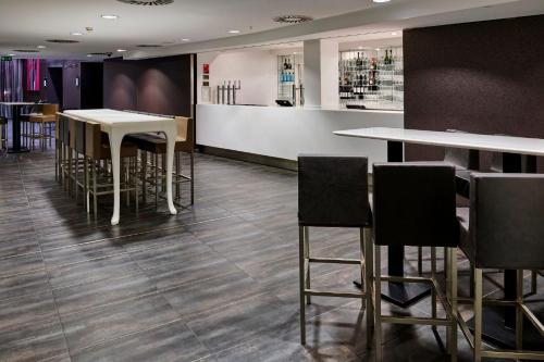 a restaurant with tables and chairs and a bar at Crowne Plaza Manchester City Centre by IHG in Manchester