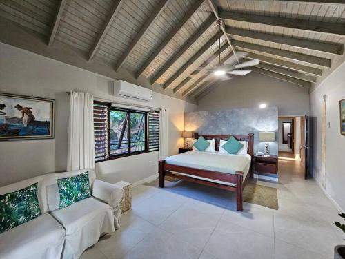 a bedroom with a bed and a couch in a room at Villa Fantasy private beach and private pool in Rio Bueno
