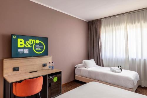 a hotel room with two beds and a tv at B&B HOTEL Cuneo Cristal in Cuneo