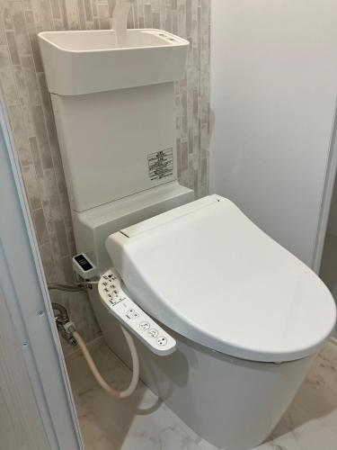 a bathroom with a white toilet and a sink at Restmance Pension Woody Hill in Iiyama
