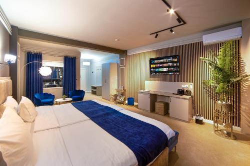 a bedroom with a large bed and a desk at Hotel Nordic Twins & Wellness in Rădăuţi