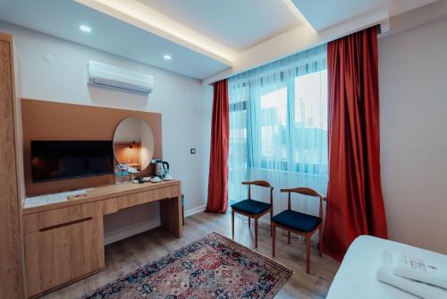 a hotel room with a desk and a mirror at Fortunella Suites in Finike