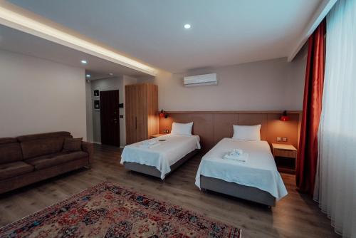 a hotel room with two beds and a couch at Fortunella Suites in Finike