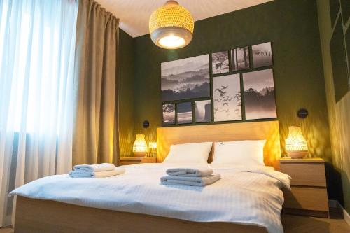 a bedroom with a bed with towels on it at Lovcevic Apartmani & Sobe in Šabac