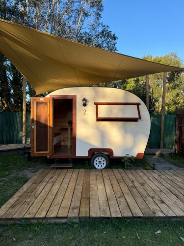 a tiny caravan with a tent on a deck at The Village Eco Stay Byron Bay in Byron Bay