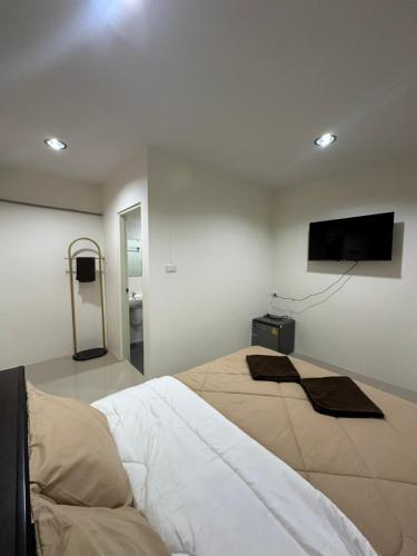 a bedroom with a bed and a flat screen tv at As-Safa Inn in Hat Yai