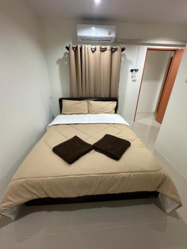 a bedroom with a bed with a bow tie on it at As-Safa Inn in Hat Yai