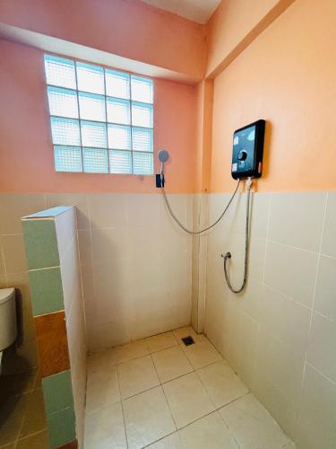 a bathroom with a toilet and a television on the wall at Moondance Cottage Inn in Ko Chang