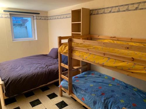 une chambre avec deux lits superposés et une fenêtre dans l'établissement Bray-Dunes avec jardin - 3chambres, à Bray-Dunes