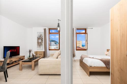 a white bedroom with a bed and a tv at Monaco Border - Bel appartement rénové - CM in Beausoleil