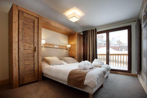a bedroom with a large bed and a window at Chalet des Neiges -La Source des Arcs in Arc 2000