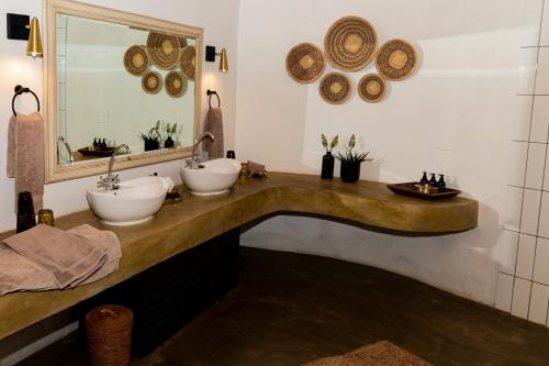 a bathroom with two sinks and a mirror at Last Word Madikwe in Madikwe Game Reserve