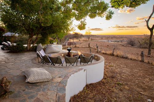 a fire pit in the middle of a field with chairs at Last Word Madikwe in Madikwe Game Reserve