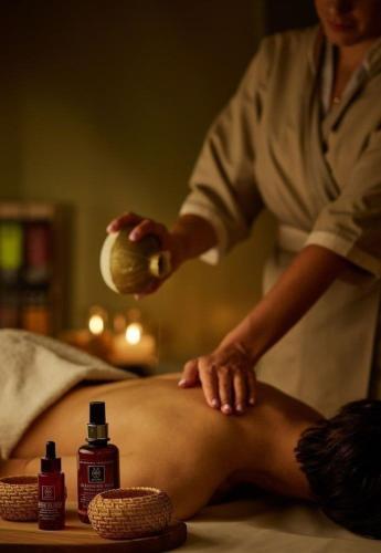 a woman in a spa giving a man a massage at Atar Airport Hotel - Spa & Wellness in Arnavutköy