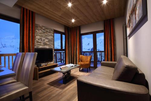 
a living room filled with furniture and a tv at Chalet des Neiges -La Source des Arcs in Arc 2000
