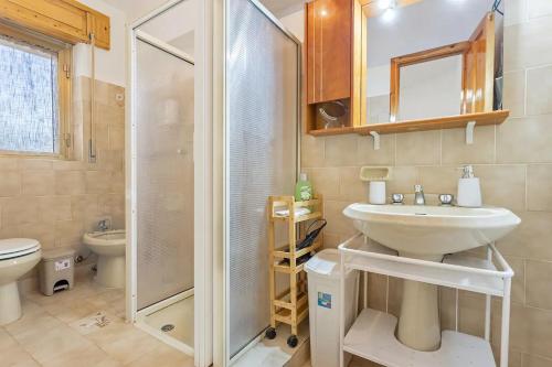 a bathroom with a shower and a sink and a toilet at Casa Marea in Marina di Gairo