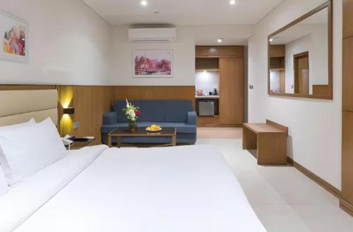 a bedroom with a large bed and a living room at Pearl Inn Paradise Hotel in Karachi