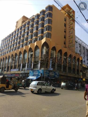 a building with a white car parked in front of it at Pearl Inn Paradise Hotel in Karachi
