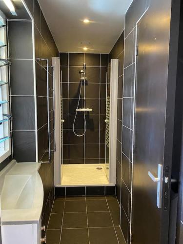 une salle de bain avec une douche avec une porte vitrée dans l'établissement Les Pieds dans l eau, à Saint-Jean-de-Luz