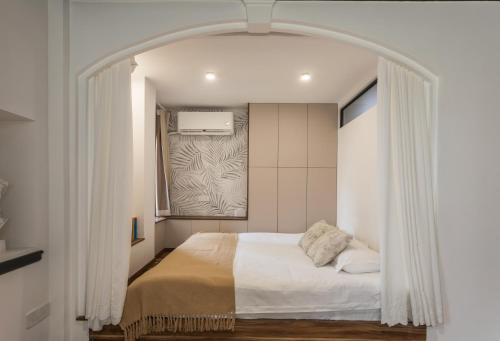 a bedroom with a white bed with an archway at Tonight Homestay West Nanjing Road Shanghai in Shanghai