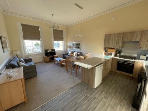 a large kitchen and living room with a table at The Osborne Apartments in Torquay