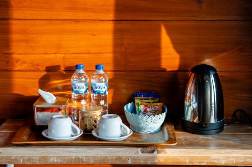 a tray with two bottles of water and a tea kettle at Pondok Devana Kintamani in Kintamani