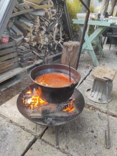 a pot of soup cooking on a campfire at Villa Evetes in Jablonov nad Turnou