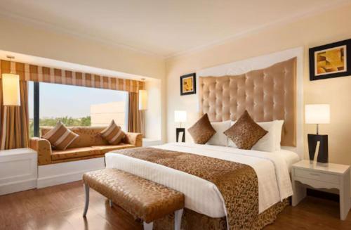 a large bedroom with a large bed and a couch at Pearl Inn Paradise Hotel in Karachi